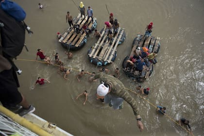 Ante la tesión que se desató, algunos migrantes se tiraron del puente al río Suchiate para cruzar el paso fronterizo