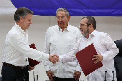 Ante Raúl Castro, el expresidente Juan Manuel Santos le estrecha la mano al líder máximos de las Farc, "Timochenko", en la firma de los Acuerdos de Paz en La Habana