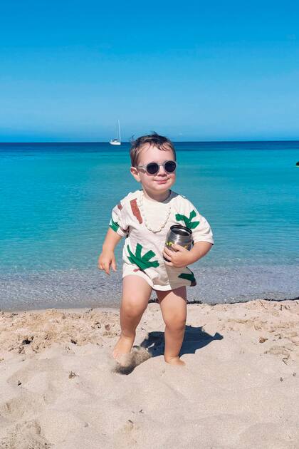 Anteojos de sol, collar de caracoles y remera pintada para sus días de playa.