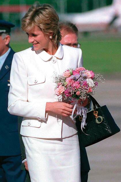 Antes de que Diana cayera ante el encanto de esta cartera con asas cortas de Christian Dior, el modelo era conocido como Chouchou, pero después de usarlo en infinidad de ocasiones, se lo rebautizó en su honor. En la foto se la ve con una de las tantas versiones que tenía, en su visita a la Argentina.