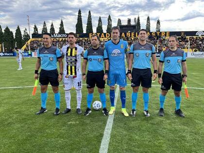 Antes del inicio del juego entre Deportivo Madryn y Almirante Brown, el 20 de octubre pasado, posan los capitanes con el juez Ceballos y sus asistentes