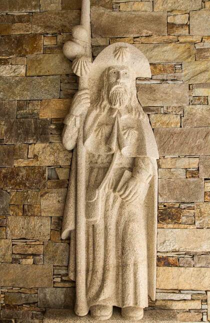 Antiguo peregrino esculpido en roca, con conchas de vieiras (el símbolo de Santiago), la calabaza y el bordón o bastón alto.