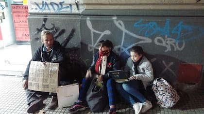 Antonella hace las tareas del colegio en la calle, en Santa Fe y Coronel Díaz; la acompañan su padre y su madre