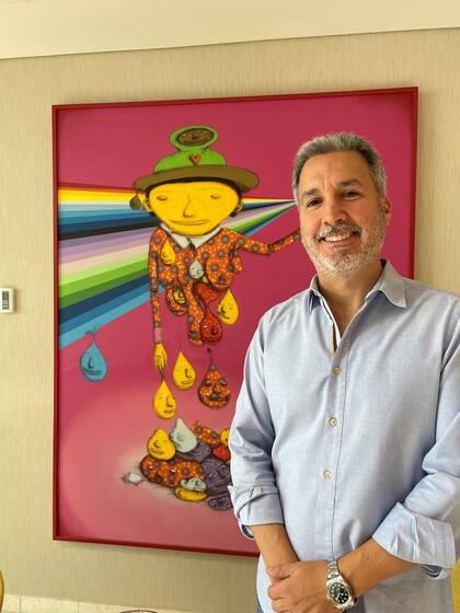 Antonio Murzi con una obra de Os Gêmeos que integra su colección de arte urbano