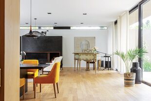 Apenas debajo del cielo raso, diseñaron una raja que toma luz desde el lateral. La chimenea en estucado negro, remite a la puerta de entrada. "Con tanto blanco y vidrio, buscamos un volumen con peso que contrastara".