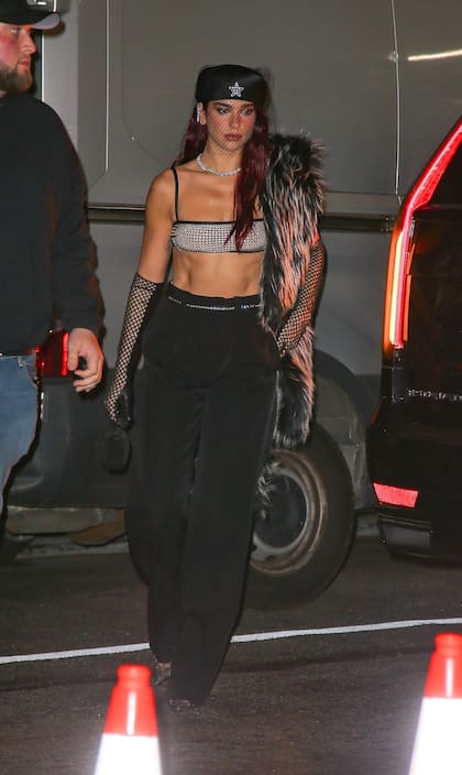 Apenas pudo, Dua Lipa se sacó el corset blanco y negro y la falda de Marc Jacobs que lució en la alfombra roja para ponerse mucho más cómoda: un pantalón negro, un top dorado y algunos toques de red, en un velo y en sus guantes largos