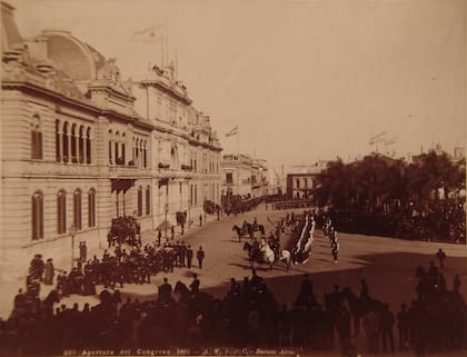 Apertura de las sesiones parlamentarias en 1892. Era una tradición que el presidente cruzara caminando desde la Casa de Gobierno para inaugurarlas. El edificio del Congreso asoma detrás de los árboles, con las banderas argentinas flameando. Se alcanza a ver la punta del frontis.