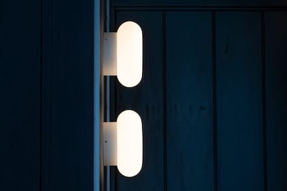 Aplique Bolton: una solución lumínica que suma diseño y una luz general suave y homogénea, aquí en el pasillo de ingreso al departamento intervenido por Leti Rocco.