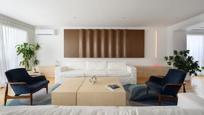 Aplique de pared (Huup). Sofás 'E' con funda de tussor off white y mesa de centro (todo de Siuk Objetos) de mármol travertino (Marmolería Forte). Nudo en cromo metálico (BoConcept).