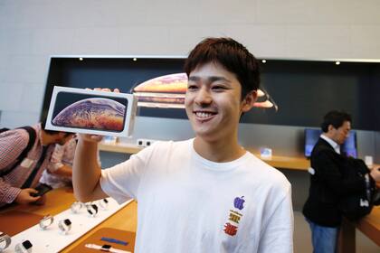 El primer comprador en la tienda de Japón muestra feliz su teléfono