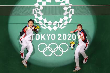 Apriyani Rahayu de Indonesia y Greysia Polii de Indonesia posan en la cancha con sus medallas de oro de bádminton en dobles femeninos