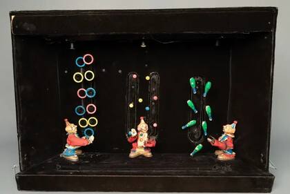 Aquí ves evidencia de dos de sus pasiones: hacer artilugios y malabarismo: 3 payasos parecen hacer malabarismos con mazas, pelotas y aros; detrás del diorama, una compleja maquinaria mantiene todo en movimiento, y un instrumento Casio VL-Tone reproduce música