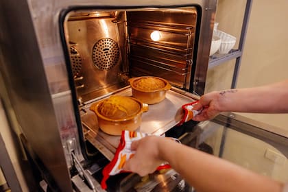 Aquino sacando sopa paraguaya recién horneada