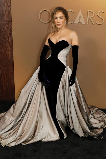 ara la gran noche, Jennifer Lopez –protagonista
de la nueva adaptación del musical El beso de
la mujer araña– optó por un traje de la colección
alta costura otoño/invierno 2025 de Tamara
Ralph. Se trata de un imponente strapless con
cintura de avispa en corset de terciopelo negro
y marfil, que combinó con una voluminosa falda
con abertura desde la cintura. Sus accesorios:
guantes de ópera y joyas Chopard