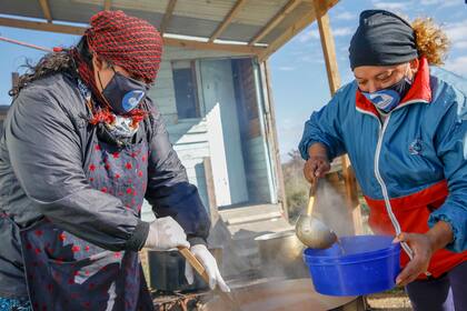 Araceli y Sandra se ocupan de servir las raciones en los potes previamente sanitizados
