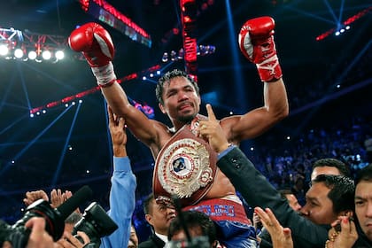 ARCHIV - Manny Pacquiao exhibe su cinturón de campeón mundial tras derrotar a Brandon Ríos en la pelea por el cetro welter del OMB, el 24 de noviembre de 2013, en Macau. (AP Foto/Vincent Yu)