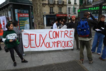 ARCHIVO - Activistas opuestos a las Olimpiadas de París despliegan una manta que dice: "Contra los Juegos Olímpicos"