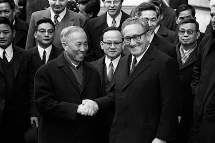 Archivo. El asesor de seguridad nacional de Estados Unidos, Henry Kissinger (derecha), estrecha la mano de Le Duc Tho, líder de la delegación norvietnamita, tras la firma de un acuerdo de alto el fuego en la guerra de Vietnam, el 23 de enero en París. (Foto de AFP)