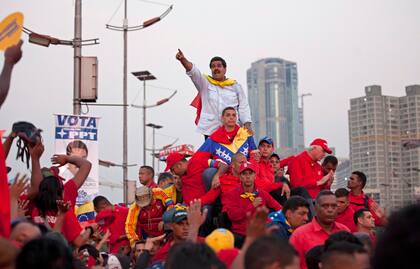 ARCHIVO - El aspirante a presidente de Venezuela Nicolás Maduro saluda a sus simpatizantes a su llegada a la avenida Bolívar para un acto de cierre de campaña en Caracas, Venezuela, el 11 de abril de 2013. Maduro, el sucesor del fallecido mandatario Hugo Chávez, ganó al candidato de la oposición Henrique Capriles en las elecciones del 14 de abril. (AP Foto/Ramón Espinosa, Archivo)