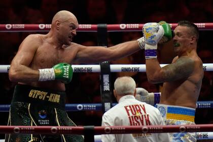 ARCHIVO - El británico Tyson Fury asesta un golpe sobre el ucraniano Oleksandr Usyk, en su combate por el título de los pesados, el 18 de mayo de 2024, en Riad