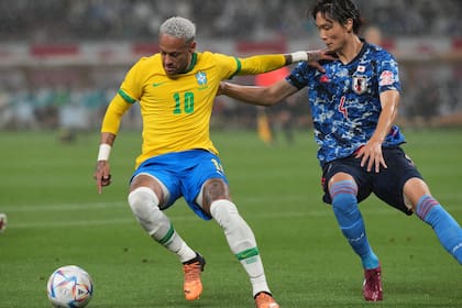ARCHIVO - El delantero brasileño Neymar (izquierda) pugna un balón con el japonés Kou Itakura durante un partido amistoso en Tokio, el lunes 6 de junio de 2022. (AP Foto/Eugene Hoshiko)
