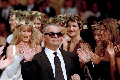 ARCHIVO - El diseñador alemán Karl Lagerfeld recibe el aplauso de sus modelos al final de su desfile para Chanel de la temporada otoño-invierno 1993-94 en París, el 20 de julio de 1993. (Foto AP/Lionel Cironneau, archivo)