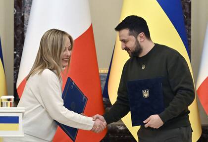 Archivo.- El presidente ucraniano, Volodimir Zelensky, y la primera ministra italiana, Giorgia Meloni, se dan la mano antes de una conferencia de prensa conjunta después de su reunión en Kiev el 21 de febrero de 2023, en medio de la invasión rusa de Ucrania