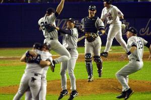 ARCHIVO - El primera base de los Yankees de Nueva York, Tino Martínez (24), salta a los brazos del lanzador Mariano Rivera mientras el receptor Jorge Posada, tercero desde la derecha, Scott Brosius (18) y otros celebran después de derrotar a los Mets de Nueva York en el Juego 5 de la Serie Mundial 4-2 para convertirse en los campeones de la Serie Mundial de 2000, el 26 de octubre de 2000, en el Shea Stadium de Nueva York. (AP Foto/Bill Kostroun, archivo)
