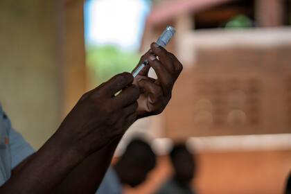 ARCHIVO - En esta foto del 11 de diciembre del 2019, trabajadores de salud se preparan para vacunar a residentes de la aldea malawi de Tomali, donde niños son inoculados con la primera vacuna para la malaria. (AP Foto/Jerome Delay)