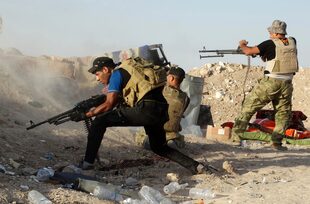 ARCHIVO - En esta fotografía del lunes 15 de junio de 2015, fuerzas de seguridad iraquíes defienden sus posiciones contra un ataque del grupo extremista Estado Islámico en Husaybah, a 8 kilómetros al este de Ramadi, Irak. (AP Foto, archivo)