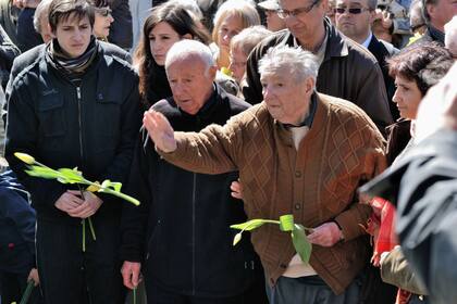 ARCHIVO.- En la imagen, Marek Edelman, el excombatiente judío más famoso, fallecido en 2009, arroja narcisos amarillos a los pies del Monumento a los Héroes del Gueto de Varsovia