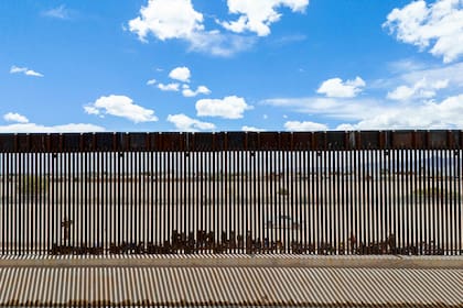 Archivo.- En una vista aérea, los migrantes que buscan asilo se agrupan junto a la valla fronteriza mientras esperan ser procesados después de cruzar ilegalmente el río Grande hacia los Estados Unidos el 25 de marzo de 2024 en El Paso, Texas