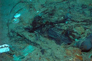 ARCHIVO - Esta fotografía de 2004 proporcionada por el Institute for Exploration, Center for Archaeological Oceanography/University of Rhode Island/NOAA Office of Ocean Exploration, muestra los restos de un abrigo y de unas botas en el fondo marino cerca del sitio donde se encuentran los restos del Titanic. (Institute for Exploration, Center for Archaeological Oceanography/University of Rhode Island/NOAA Office of Ocean Exploration, Archivo)