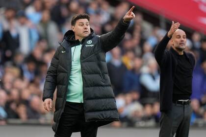 ARCHIVO - Foto del sábado 20 de abril del 2023, el entrenador del Chelsea Mauricio Pochettino y Pep Guardiola del Mánchester City en la semifinal de la Copa FA. (AP Foto/Alastair Grant)