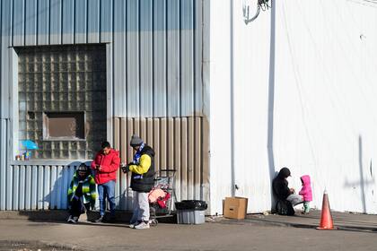 ARCHIVO - Inmigrantes frente a un refugio en el vecindario de Pilsen en Chicago, el 19 de diciembre de 2023. (AP Foto/Charles Rex Arbogast, Archivo)