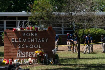 ARCHIVO - Investigadores buscan pruebas afuera de la escuela primaria Robb en Uvalde, Texas, el 25 de mayo de 2022, tras la masacre a tiros de 19 niños y dos maestras en el lugar.(AP Foto/Jae C. Hong, Archivo)