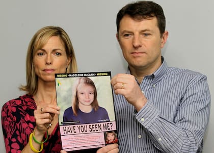 ARCHIVO - Kate y Gerry McCann posan para los medios con un cartel de búsqueda que ofrece una imagen generada por computadora sobre la posible progresión de la edad de su hija Madeleine, que desapareció en Portugal en 2007, durante una conferencia de prensa en Londres, el 2 de mayo de 2012. (AP Foto/Sang Tan, archivo)