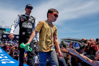 ARCHIVO - Kyle Busch, izquierda, y su hijo, saludan a los fanáticos previo a una carrera de la NASCAR Cup Series en Talladega Superspeedway, el 23 de abril de 2023, en Talladega, Alabama. (AP Foto/Butch Dill, Archivo)