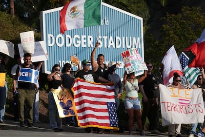 ARCHIVO - Manifestantes protestan contra las redadas migratorias frente al estadio de los Dodgers el 21 de junio de 2025, en Los Ángeles. (AP Foto/Damian Dovarganes, archivo)