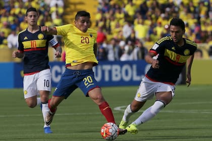 ARCHIVO - Mario Pineida, de la selección de Ecuador, conduce un balón frente a Abel Aguilar de Colombia en un partido de las eliminatorias mundialistas realizado el 28 de marzo de 2017 (AP Foto/Dolores Ochoa, archivo)