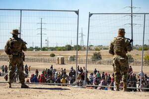 ARCHIVO - Migrantes esperan junto a una valla fronteriza bajo la vigilancia de la Guardia Nacional de Texas para ingresar a El Paso, Texas, el 10 de mayo de 2023. (AP Foto/Andres Leighton)