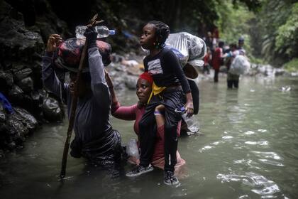 ARCHIVO - Migrantes haitianos atraviesan partes de agua al pasar por el Tapón del Darién desde Colombia a Panamá en su larga y compleja ruta para llegar hasta Estados Unidos (AP Foto/Iván Valencia, Archivo)