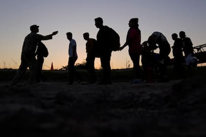 Archivo.- Migrantes que cruzaron el río Grande (Bravo) y entraron a Estados Unidos desde México forman una fila para ser procesados por la Oficina de Aduanas y Protección Fronteriza de Estados Unidos, el 23 de septiembre de 2023, en Eagle Pass, Texas (AP Foto/Eric Gay, Archivo)