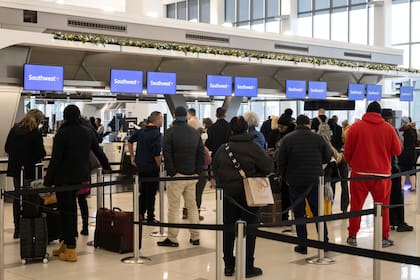 ARCHIVO - Pasajeros esperan para registrarse para sus vuelos en un mostrador de la aerolínea Southwest Airlines en el Aeropuerto de LaGuardia, el 27 de diciembre de 2022, en Nueva York. (AP Foto/Yuki Iwamura, Archivo)