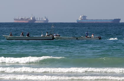 ARCHIVO - Pescadores trabajan frente a buques tanque al sur del estrecho de Ormuz, el 19 de enero de 2012, frente a la ciudad de Ras Al Khaimah, Emiratos Árabes Unidos. (AP Foto/Kamran Jebreili, archivo)