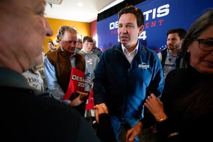ARCHIVO - Ron DeSantis, gobernador de Florida y aspirante a la candidatura republicana para la presidencia, centro, conversa con partidarios en un acto de campaña, el viernes 3 de noviembre de 2023, en Denison, Iowa