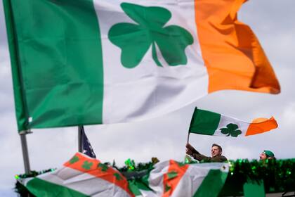 ARCHIVO - Un hombre ondea una bandera irlandesa mientras mira el desfile por el Día de San Patricio, el domingo 17 de marzo de 2024, en Boston. (AP Foto/Steven Senne, archivo)