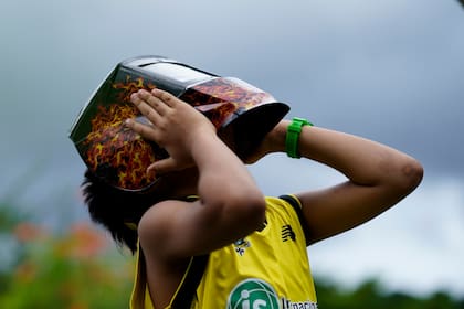 Archivo.- Un niño sostiene una máscara para proteger sus ojos mientras la gente se reúne para ver el eclipse anular solar en la Ciudad de Panamá, el 14 de octubre de 2023