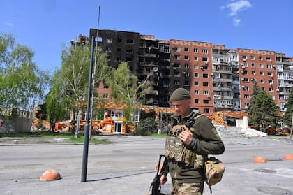 ARCHIVO – Un soldado ucraniano pasa frente a edificios dañados en el centro de Pokrovsk, en la región ucraniana de Donetsk, el 23 de abril de 2025; esta semana, esa ciudad fue tomada por tropas rusas