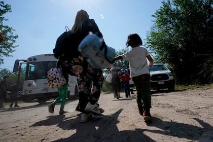 ARCHIVO - Una familia de migrantes venezolanos se dirige hacia un autobús de la Patrulla Fronteriza después de que cruzaran con otras personas de México hacia Estados Unidos y se entregaran a las autoridades, el miércoles 17 de junio de 2021, en Del Rio, Texas. (AP Foto/Eric Gay, Archivo)